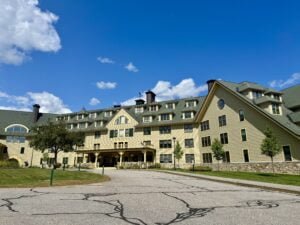 A grand hotel building with green roofs and mountain views in Waterville Valley, New Hampshire