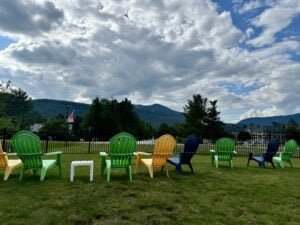 Brightly colored Adirondack chairs facing a mountain view in Waterville Valley, New Hampshire