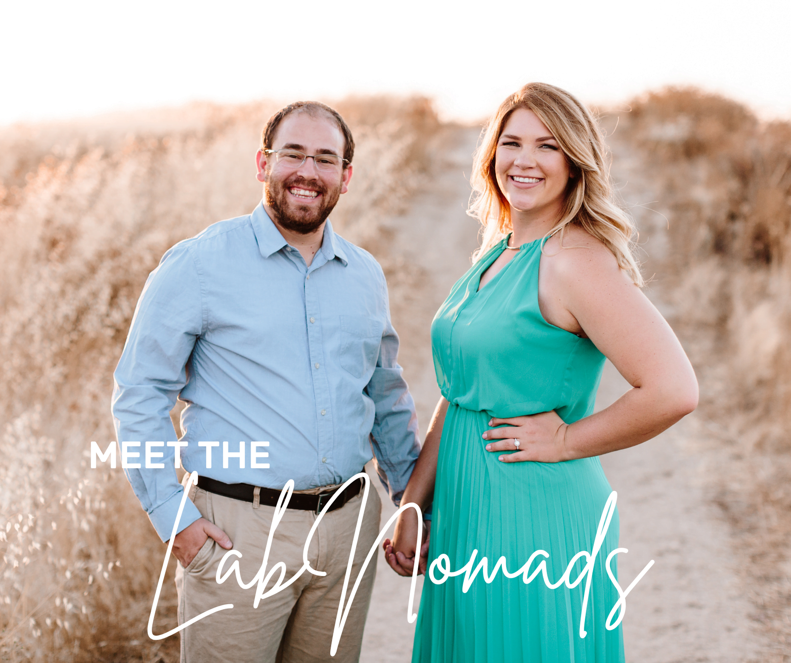 Chelsey and Anthony standing in a field, holding hands and smiling at the camera