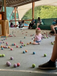 Toddler sitting in the Loopy Lab play area at Story Land surrounded by colorful balls.