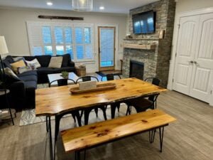 Dining and living area at Cranmore Mountain Resort Airbnb with a wooden table and cozy seating.