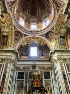 Intricate interior of St. Peter's Basilica dome with Renaissance art and ornate details in Vatican City.