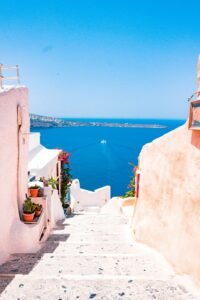 A stunning view of Santorini’s white-washed buildings, cascading down towards the Aegean Sea under a bright blue sky.